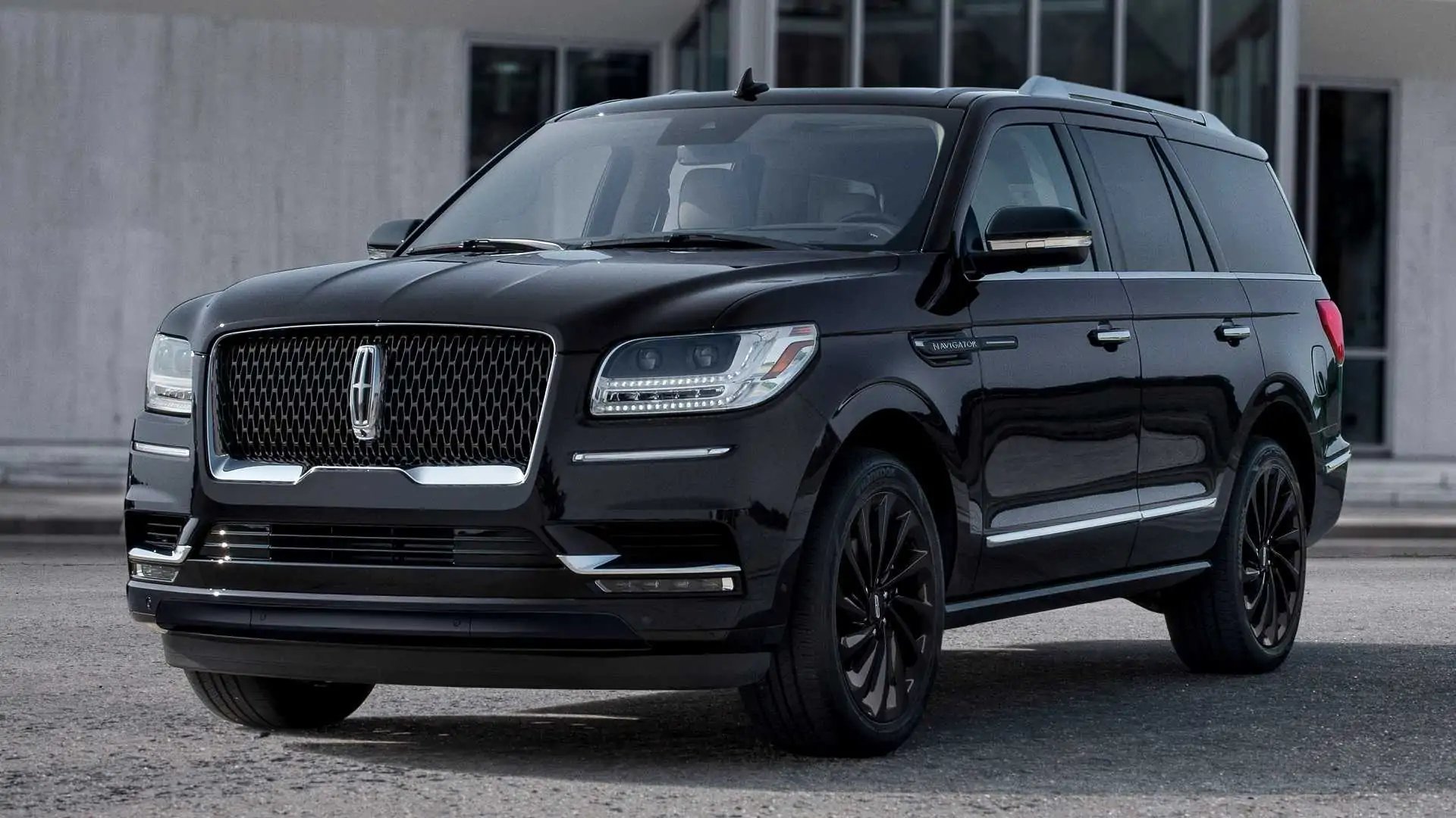 Black Lincoln Navigator SUV parked in front of a modern building